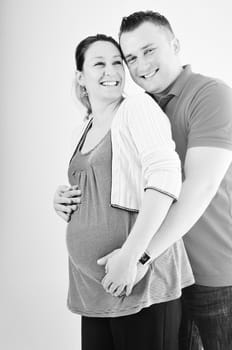 young family couple together in studio isolated on white. happy and waiting for baby