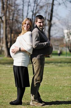 happy young married family couple outdoor in nature have fun and waiting baby and representing young family growth and pregnancy concept