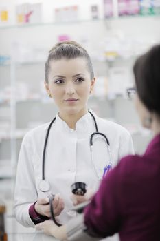 doctor checking blood pressure and heart rate in a hospital or in pharmacy with young female patient