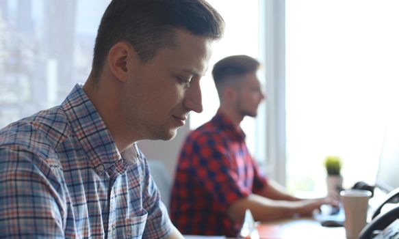 Startup business, two handsame businessmen working on computer at modern office