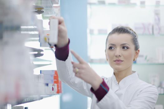 Happy cheerful pharmacist chemist woman standing in pharmacy drugstore