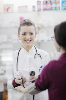 doctor checking blood pressure and heart rate in a hospital or in pharmacy with young female patient