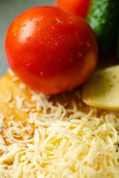 Picture with focus on washed red tomato lies on the table with drops of water on it