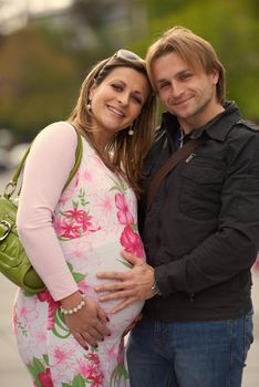 Happy and young pregnant couple have fun and relax outdoor