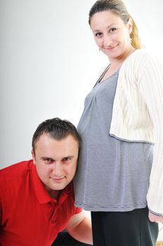 young family couple together in studio isolated on white. happy and waiting for baby