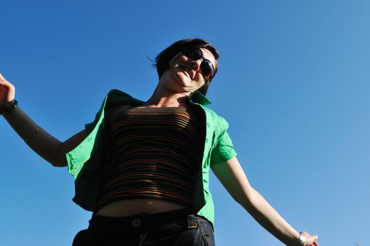 young beautiful brunette woman jump outdoor in fashion clothing and sunglasses