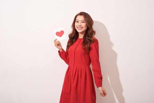 Lovely female with red heart isolated on gray background, celebration of Valentine day, romantic feelings, harmony and love concept