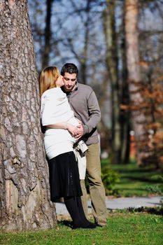 happy young married family couple outdoor in nature have fun and waiting baby and representing young family growth and pregnancy concept