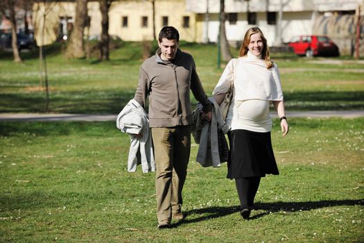 happy young married family couple outdoor in nature have fun and waiting baby and representing young family growth and pregnancy concept