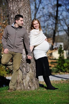 happy young married family couple outdoor in nature have fun and waiting baby and representing young family growth and pregnancy concept