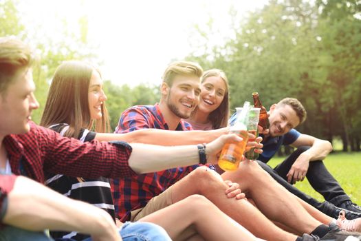 happy young friends enjoying picnic and eating.