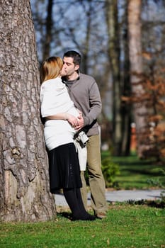 happy young married family couple outdoor in nature have fun and waiting baby and representing young family growth and pregnancy concept