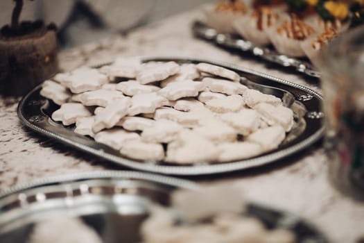 picture of a lot of white star cookies on a silver plate on the table