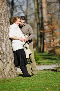 happy young married family couple outdoor in nature have fun and waiting baby and representing young family growth and pregnancy concept