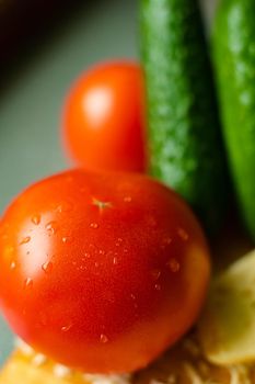 Picture with focus on washed red tomato lies on the table with drops of water on it