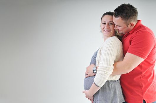 young family couple together in studio isolated on white. happy and waiting for baby