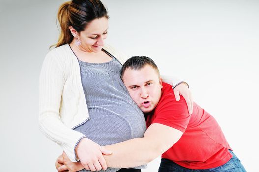 young family couple together in studio isolated on white. happy and waiting for baby