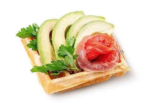 French waffle with avocado and salmon isolated on white background