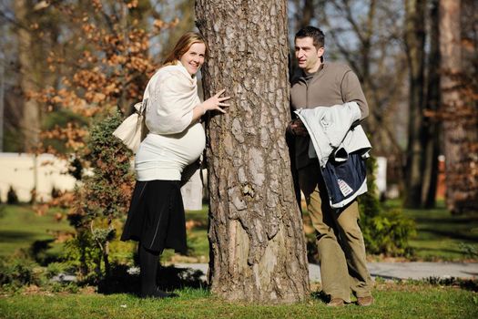 happy young married family couple outdoor in nature have fun and waiting baby and representing young family growth and pregnancy concept