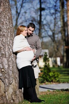 happy young married family couple outdoor in nature have fun and waiting baby and representing young family growth and pregnancy concept