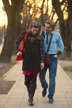 Happy and young pregnant couple have fun and relax outdoor