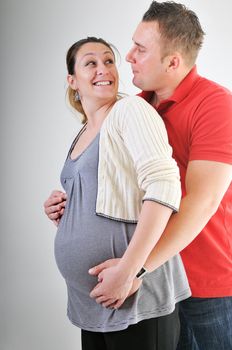 young family couple together in studio isolated on white. happy and waiting for baby