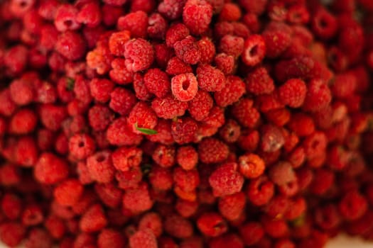 Top view of heap of red ripe raspberries after harvesting. Pile of fresh and delicious raspberries.