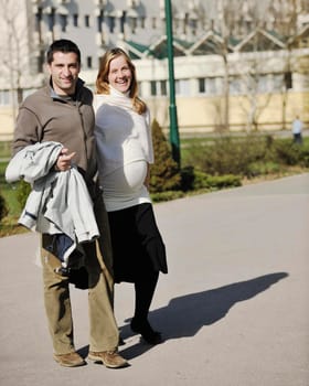 happy young married family couple outdoor in nature have fun and waiting baby and representing young family growth and pregnancy concept