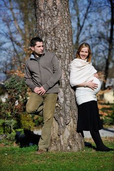 happy young married family couple outdoor in nature have fun and waiting baby and representing young family growth and pregnancy concept