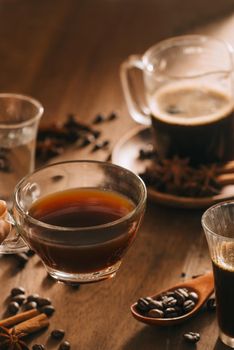 Cups of coffee with coffee beans on wooden background