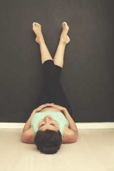 happy pregnant women enjoying pregnancy with feet raised on the black chalkboard while laying on the floor