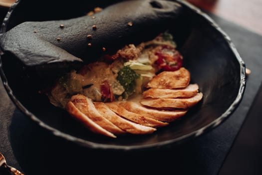 Close up photo of a meal consisting of sliced meat with some bread and salad in a bowl. Food concept