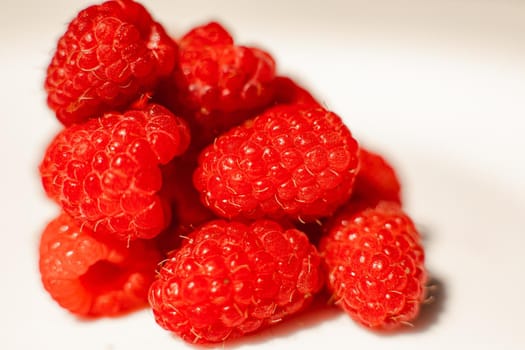 Picture of raspberries in triangle shape lies isolated on a white background. Cut out, close up. Background and picture for postcard.