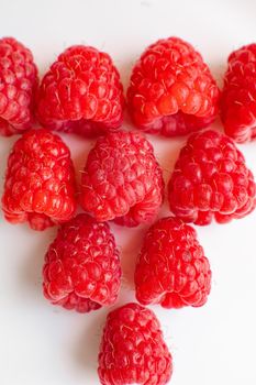 Picture of raspberries in triangle shape lies isolated on a white background. Cut out, close up. Background and picture for postcard.