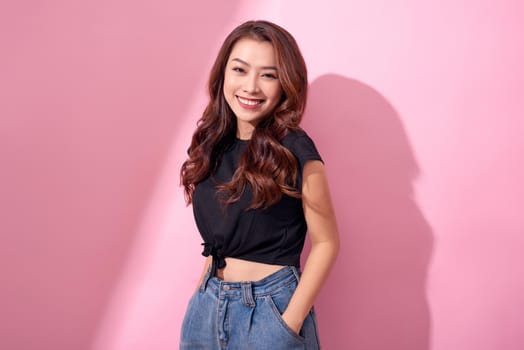 beautiful portrait Asian cheerful young girl posing in casual clothes with beaming smile standing isolated on pink background 