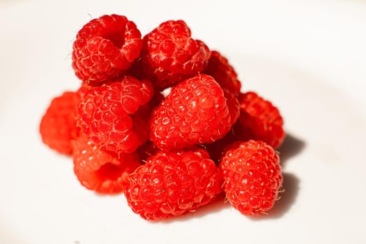 Stock photo close-up of juicy raspberries sorted on white background. Isolated on white background.