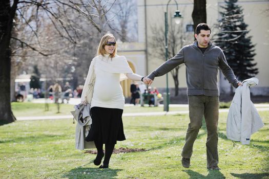 happy young married family couple outdoor in nature have fun and waiting baby and representing young family growth and pregnancy concept