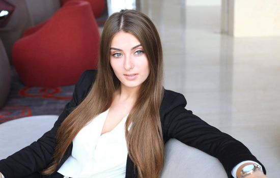 businesswoman sitting sofa using smartphone in coffee shop.