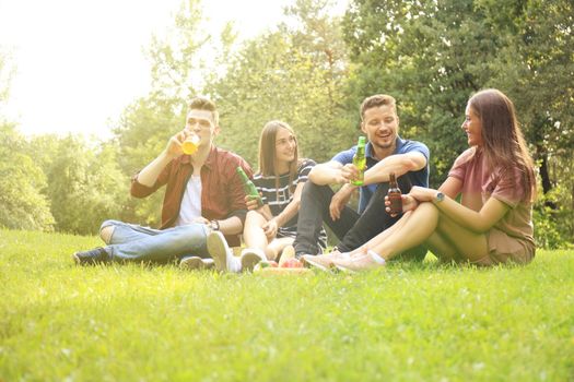 happy young friends enjoying picnic and eating.