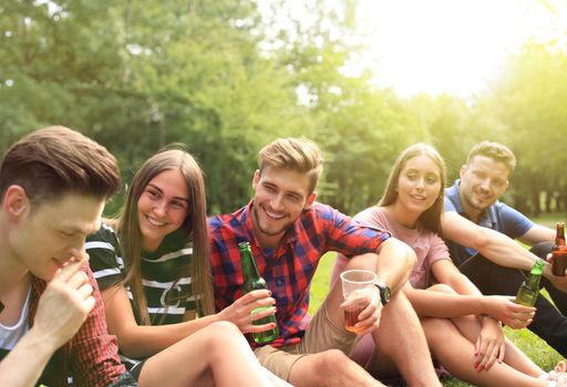 happy young friends enjoying picnic and eating.