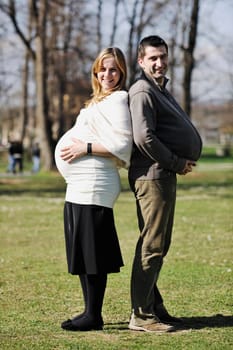 happy young married family couple outdoor in nature have fun and waiting baby and representing young family growth and pregnancy concept