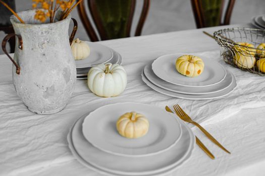 picture of sweet pumpkin cakes on the white plates on big table in light room