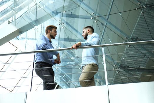 Bottom view. Two businessmen in casual wear discussing at office during business meeting