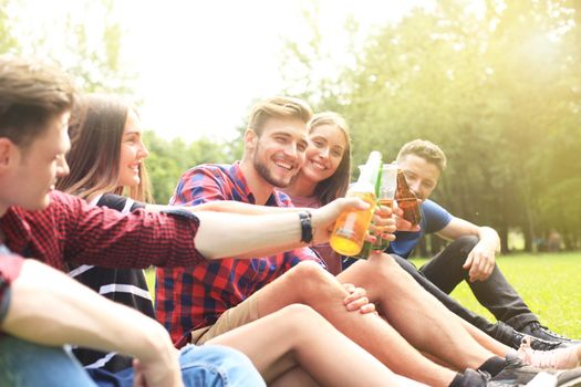 happy young friends enjoying picnic and eating.