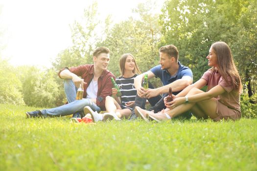 happy young friends enjoying picnic and eating.