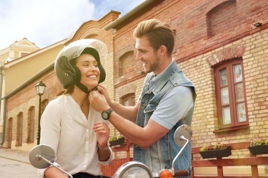 happy young couple riding scooter in town. Handsome guy and young woman travel. Adventure and vacations concept.