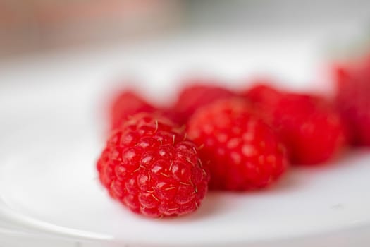 Stock photo close-up of juicy raspberries sorted on white background. Isolated on white background.