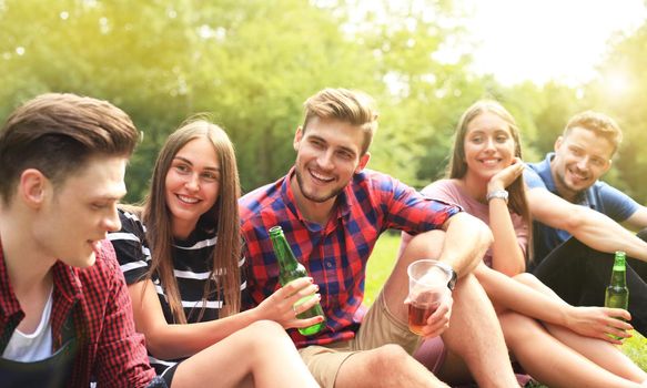 happy young friends enjoying picnic and eating.