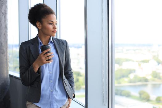Attractive african american business woman smiling while standing in the office