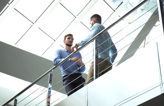 Bottom view. Two businessmen in casual wear discussing at office during business meeting